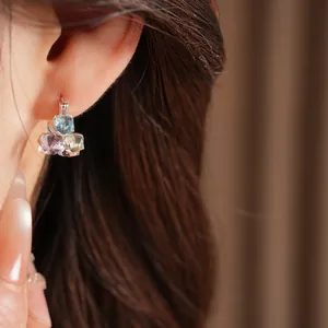 Detailed shot of multi-colored geometric glass square earrings worn on a model's ear