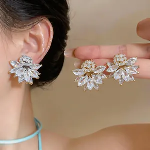 Close-up of French vintage flower earrings with marquise zirconia in gold and silver.