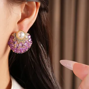 Détail macro exquis d'une boucle d'oreille vintage avec perle et gemmes ovales violettes