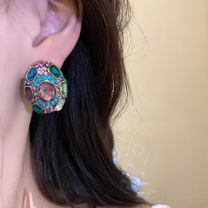 Close-up detail of vintage stud earring with colorful crystals and mauve center stone