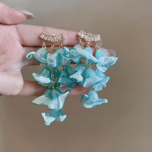 Close-up detail of light blue chiffon flower tassel earrings with elegant zircon studs
