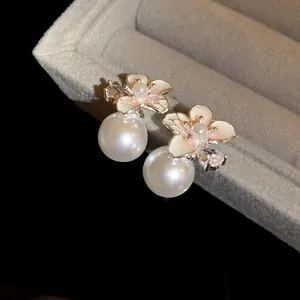 Vista dettagliata ed elegante di orecchini a fiore con perle e zirconi brillanti
