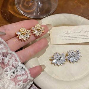 Detailed view of French vintage floral ear clips with marquise-cut clear crystals.
