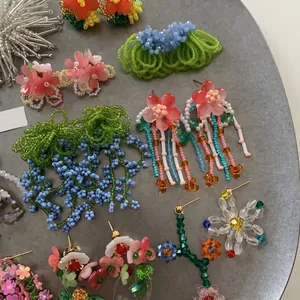 Detailed view of various floral beaded earrings in vibrant summer vacation styles.