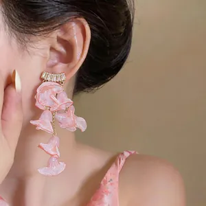 Macro view of elegant pink chiffon floral tassel earrings with shiny zircon studs