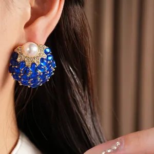 Gros plan détaillé de boucles d'oreilles vintage en or avec perle et pierres bleues