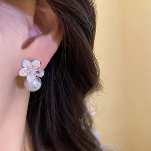 Primo piano dettagliato di eleganti orecchini a fiore con dettagli in perla e zircone