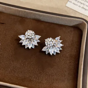 Close-up of elegant flower-shaped ear clips with sparkling marquise-cut stones.