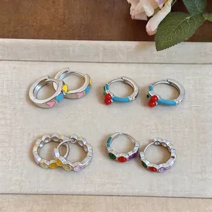 Set of colorful geometric enamel hoop earrings with heart, cherry, and smiley designs