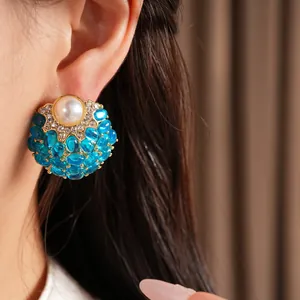 Gros plan de boucles d'oreilles vintage avec une perle et grappes de perles bleues