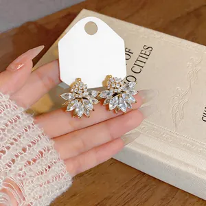 Detailed close-up of French vintage crystal flower ear clips on a white display card.