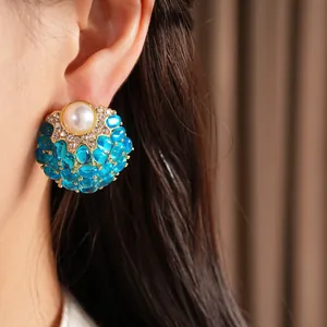 Vue macro détaillée d'élégantes boucles d'oreilles vintage avec perle et pierres bleues