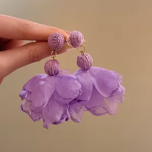 Close-up detail of purple raffia and chiffon flower petal drop earrings for women