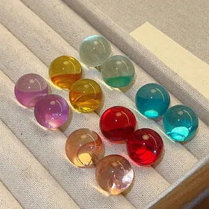 Close-up view of colorful round resin stud earrings arranged on a velvet display tray