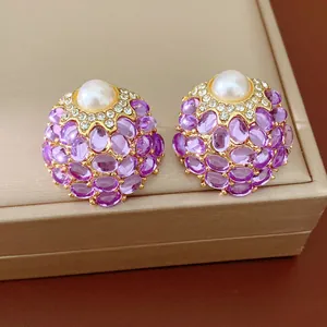 Vue macro détaillée de boucles d'oreilles vintage avec perles blanches et pierres violettes