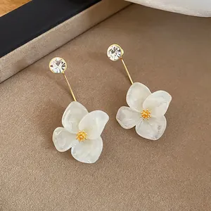 Detailed close-up view of elegant white chiffon flower stud earrings with clear rhinestones