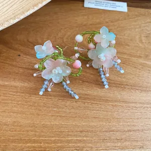 Close-up of handmade forest style beaded flower drop earrings on wooden background
