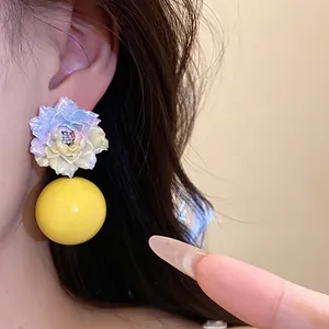 Elegant resin flower earrings with yellow bead drop on model, perfect for vacation.
