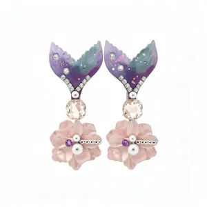 Elegant mermaid tail and flower hair clips with crystals and pearls on white background.