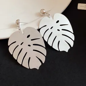 Dettaglio ravvicinato di orecchini a forma di foglia di Monstera in argento traforato