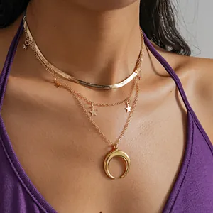 Detailed view of gold multi-layered necklace with star charms and crescent moon pendant