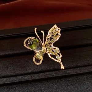 Detailed macro view of a green zircon butterfly earring with 18K rose gold plating