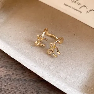 Macro view of gold-plated double-layer ear cuff with delicate bow designs