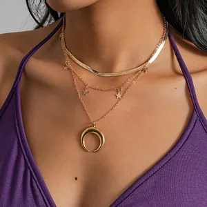 Detailed close-up view of a gold-tone layered necklace with crescent moon and stars.