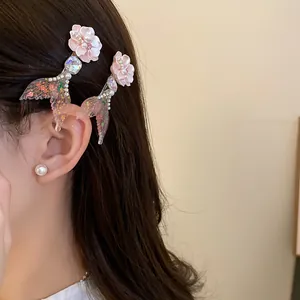 Close-up of elegant mermaid tail and pink flower hair clips styled on dark brown hair