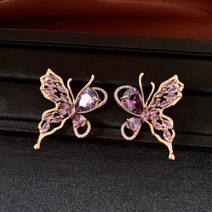 Macro view of detailed 18K gold plated butterfly stud earrings with purple zircons