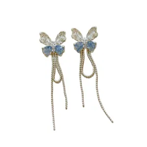 Orecchini a farfalla traforati in argento con cristalli blu e lunghe nappe a catena delicata