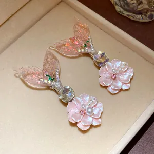 Detail view showing exquisite mermaid tail and flower hair clips decorated with pearls and gems