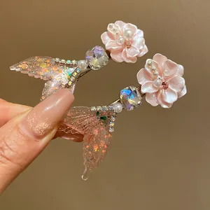 Detailed macro shot of pink glitter mermaid tail hair clips with crystal flower decoration