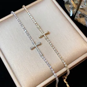 Elegant 18k gold plated zirconia cross bracelets displayed on a premium jewelry box.