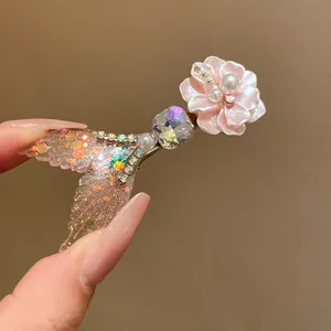 Detailed view of the elegant mermaid tail hair clip featuring pearls and flower accent