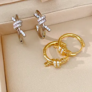 Close-up of 14k gold plated knotted hoop earrings with sparkling cubic zirconia.