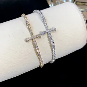 Close-up of gold and silver 18k gold-plated cross bracelets with pavé zircons