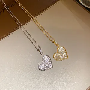 Detailed close-up showing gold and silver heart pendants with sparkling pave-set zircons.