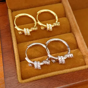 Close-up detail of 14k gold and silver plated knotted hoop earrings with sparkly zircons