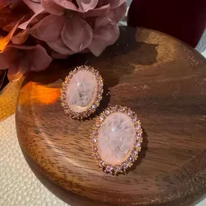 Dettaglio macro di orecchini ovali di lusso con cristalli rosa in stile retrò palazzo