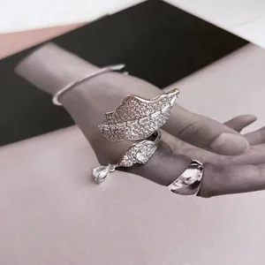 Macro view of exquisite silver-tone leaf ring with sparkling pave zircons and drop stone
