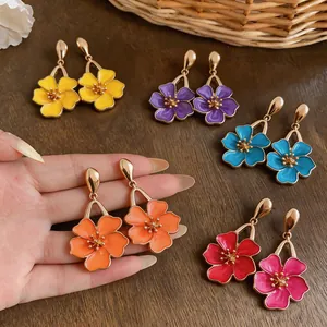 Detailed view of colorful enamel flower drop earrings in various vibrant colors
