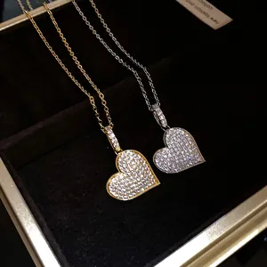 Detailed macro view of two CZ pavé heart pendant necklaces in gold and silver finishes.