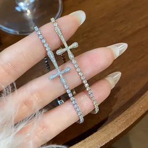 Detail view of 18k gold-plated zircon cross bracelets in gold and silver tones