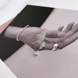 Detail of an elegant silver leaf and teardrop open ring with zircon pavé setting