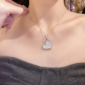 Close-up view of a sparkling zircon heart pendant necklace on a female model's neck