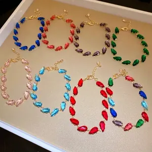 Elegant colorful teardrop zircon bracelets with gold plating shown on champagne tray