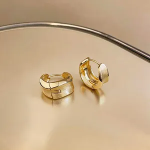 Detailed view of 18K gold-plated hoop earrings featuring a brushed metal texture.
