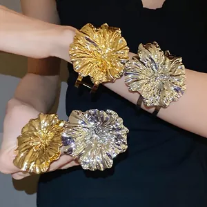 Dramatic metallic ruffled flower cuff bracelets in shiny gold and silver finishes