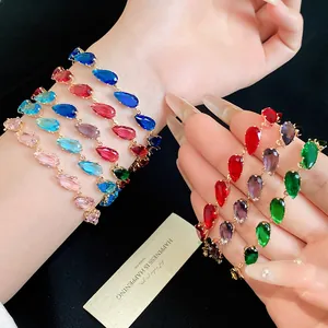 Close-up of vibrant teardrop-shaped zircon bracelets in multiple colors on a hand